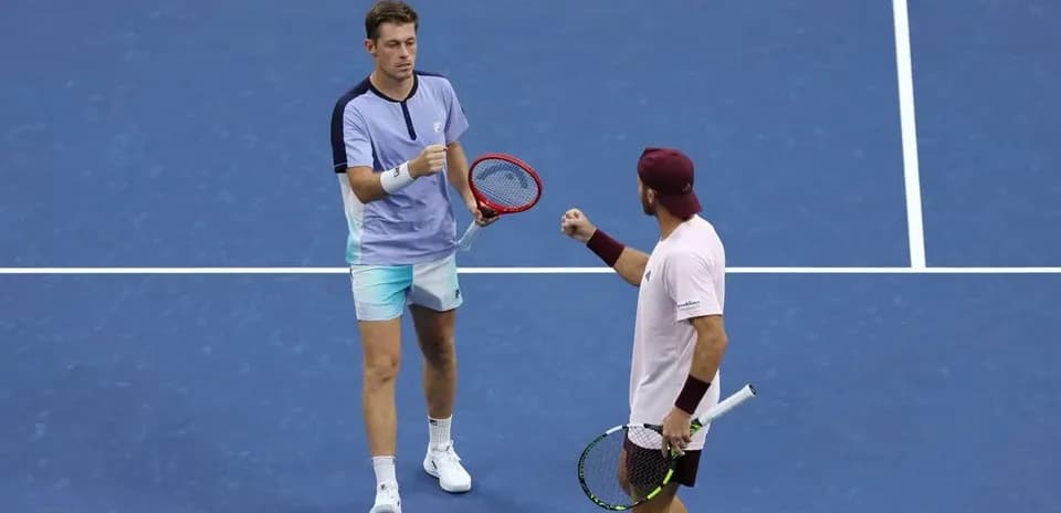Deux joueurs de tennis célébrant un point sur le court