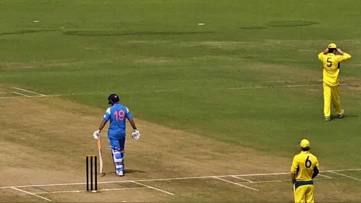 Batsman in blue uniform walking towards the pitch