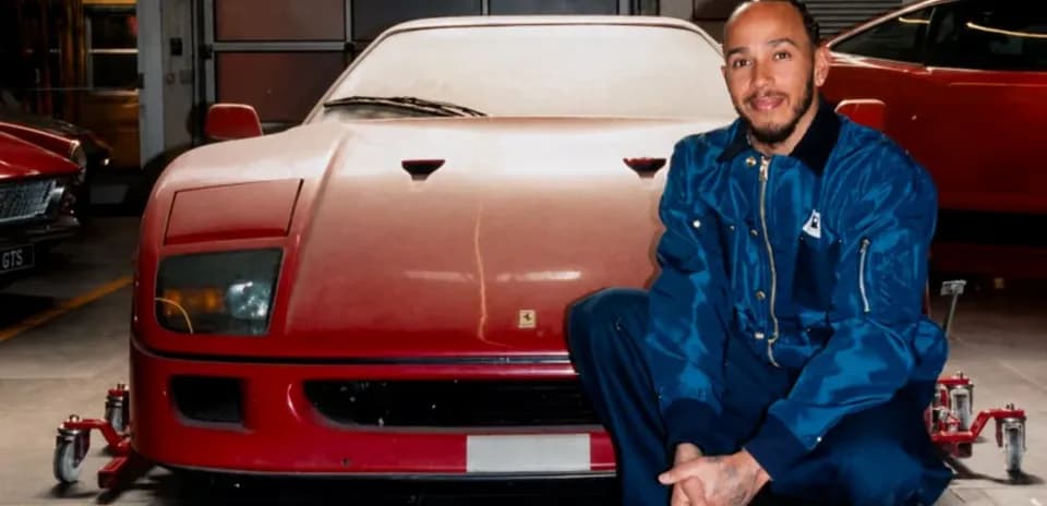 Homme squattant devant une Ferrari rouge dans un garage