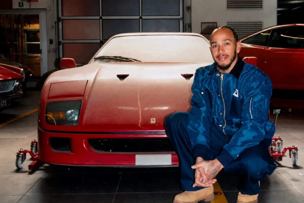 Homme squattant devant une Ferrari rouge dans un garage