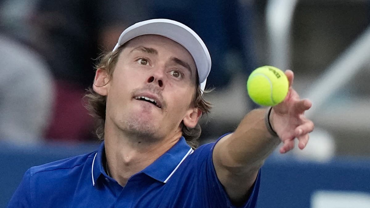 Joueur de tennis servant avec une balle jaune