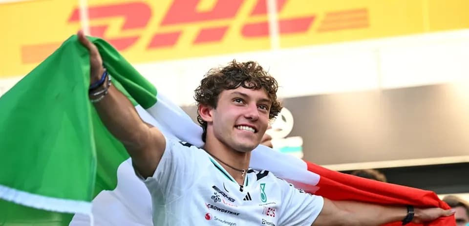 Pilote tenant un drapeau italien après la victoire