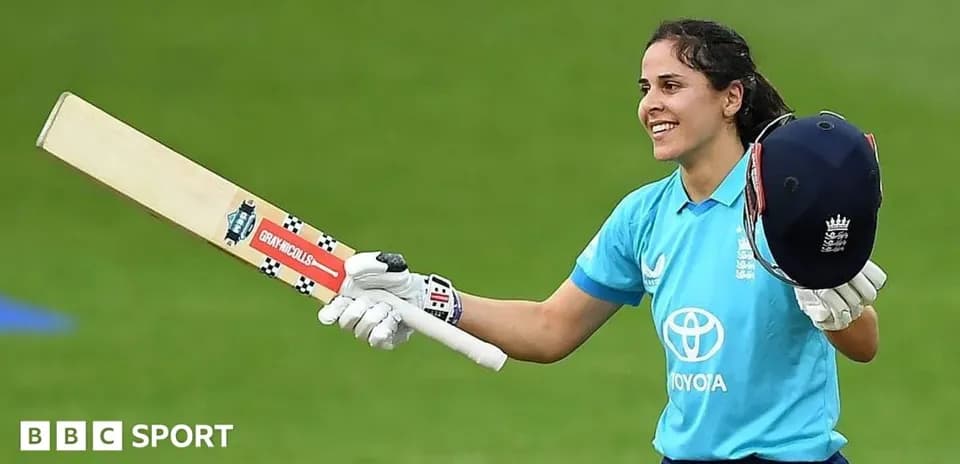 Joueuse de cricket levant sa batte et son casque