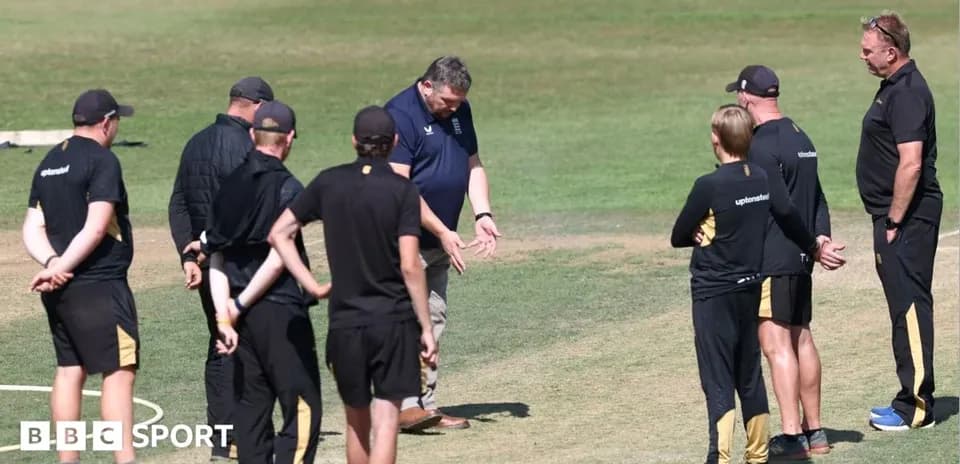 Groupe d'entraîneurs discutant sur le terrain de cricket