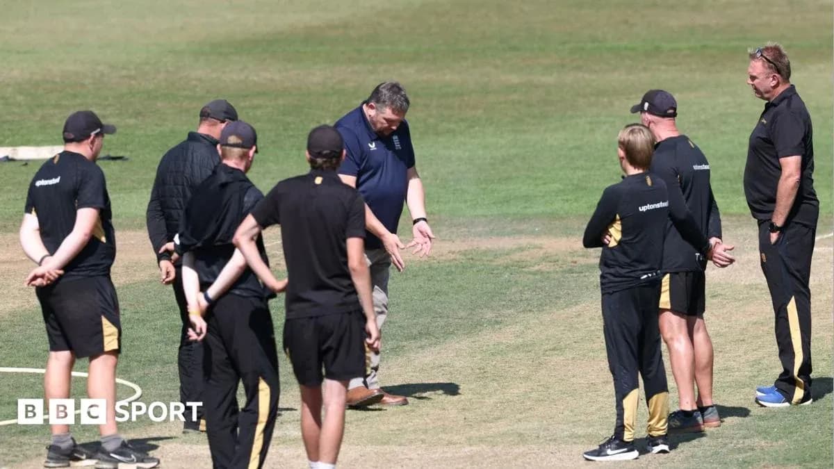 Groupe d'entraîneurs discutant sur le terrain de cricket