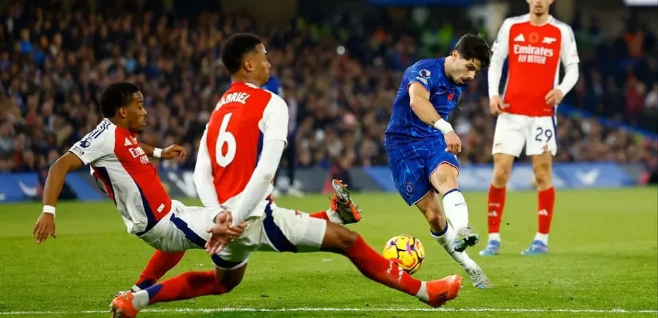 Joueur de Chelsea tirant au but entre deux défenseurs d'Arsenal