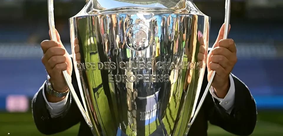 Trophée de la Ligue des champions en main