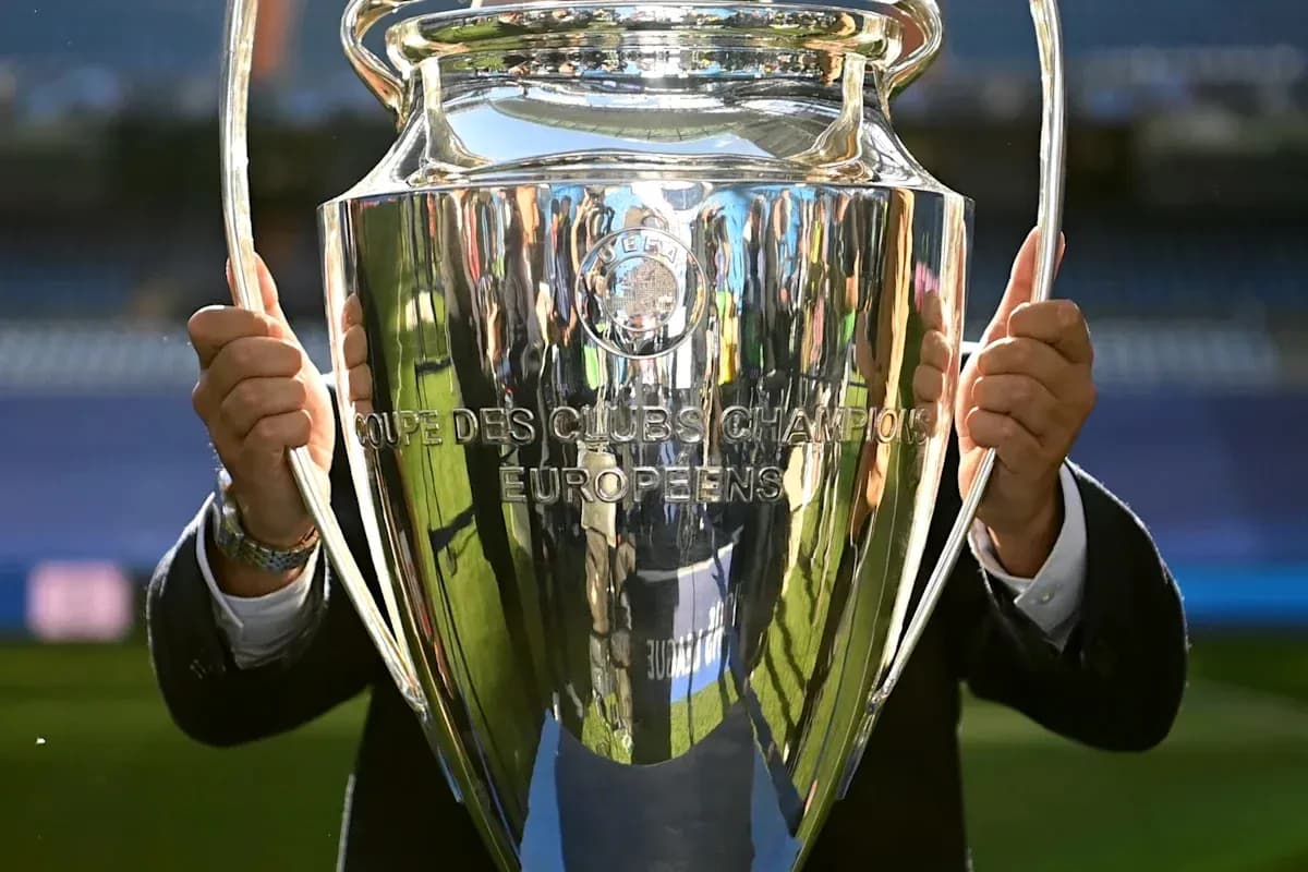 Trophée de la Ligue des champions en main