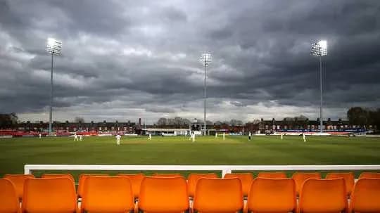 Match de cricket sous un ciel nuageux au stade
