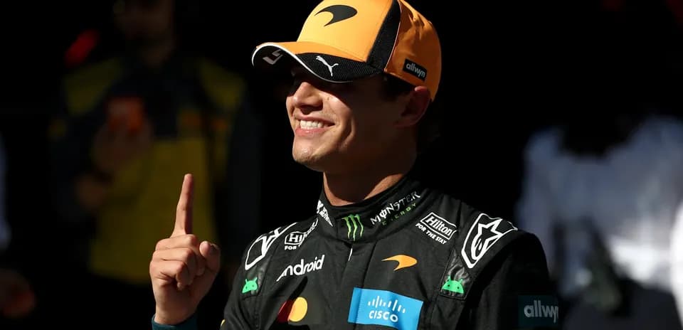 Pilote de F1 avec un chapeau McLaren montrant un doigt