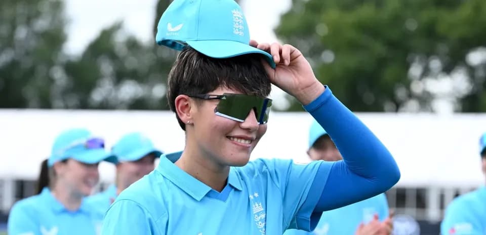 Joueuse de cricket portant une casquette bleue