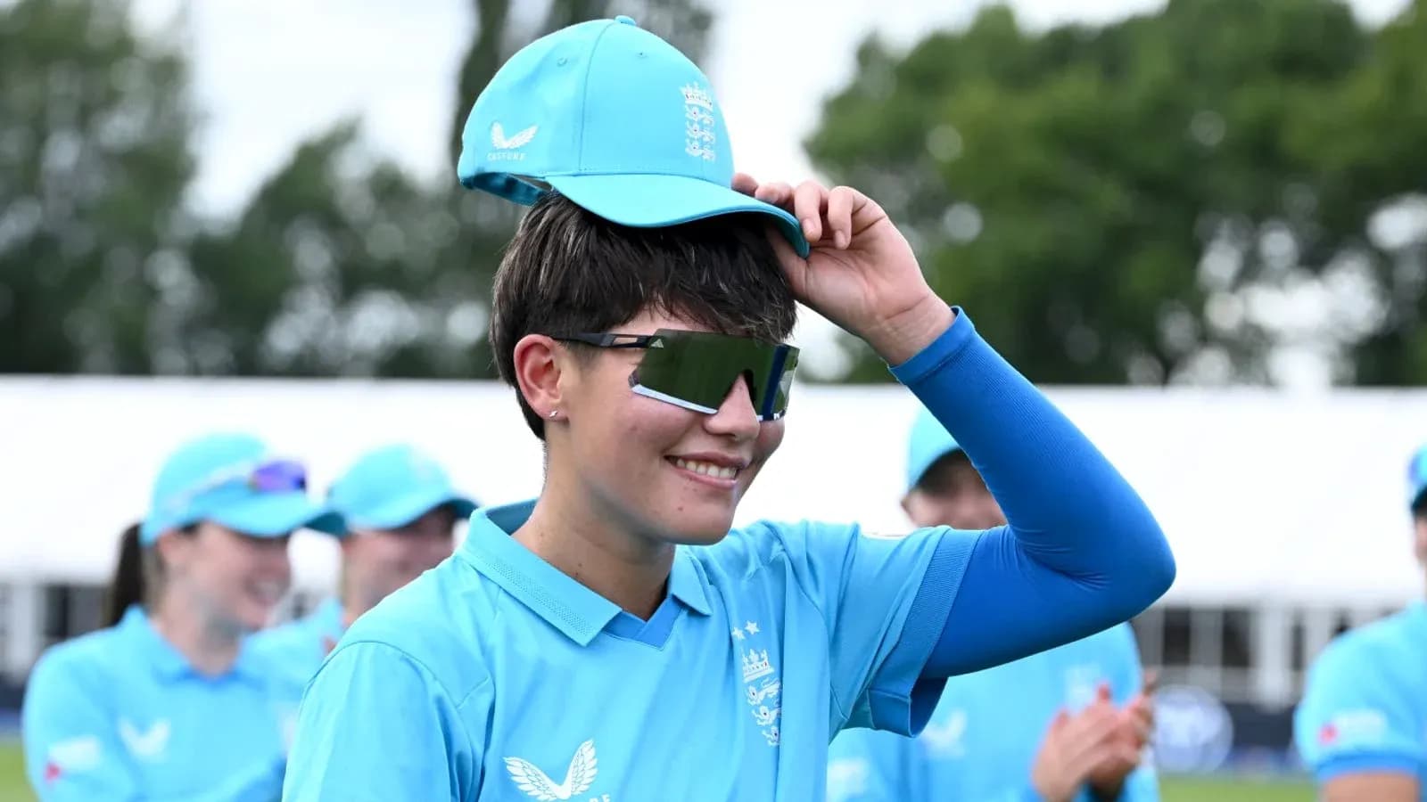Joueuse de cricket portant une casquette bleue
