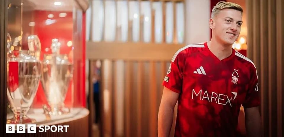 Joueur de Nottingham Forest en maillot rouge près des trophées