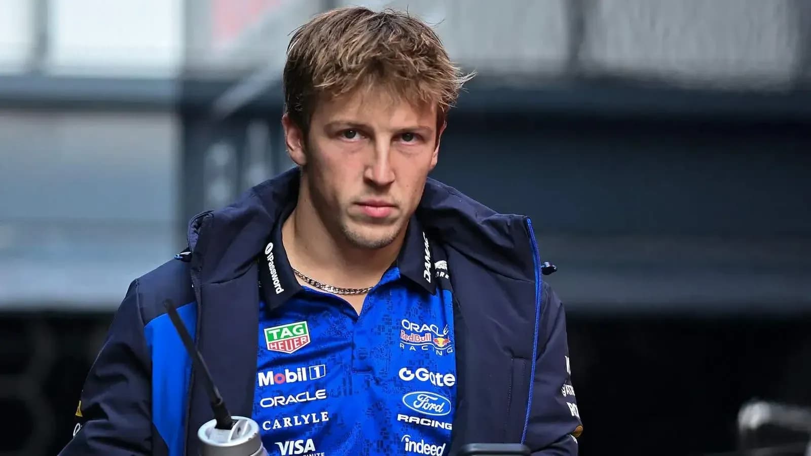 Pilote de F1 portant une veste d'équipe dans le paddock