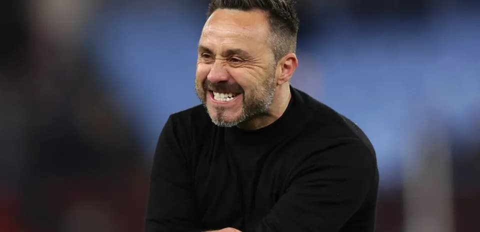 Entraîneur souriant sur le terrain après un match