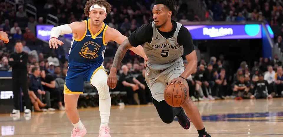 Joueur de San Antonio dribblant, poursuivi par un joueur de Golden State