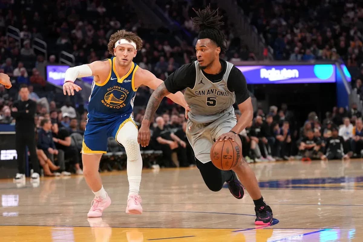 Joueur de San Antonio dribblant, poursuivi par un joueur de Golden State