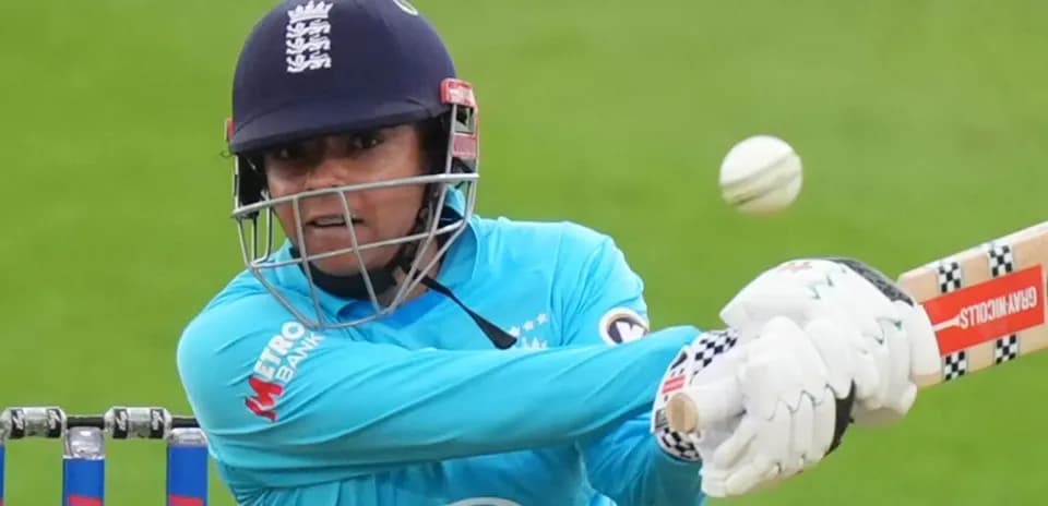 Joueuse frappant la balle de cricket avec sa batte