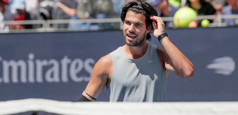 Joueur de tennis ajustant ses cheveux sur le court