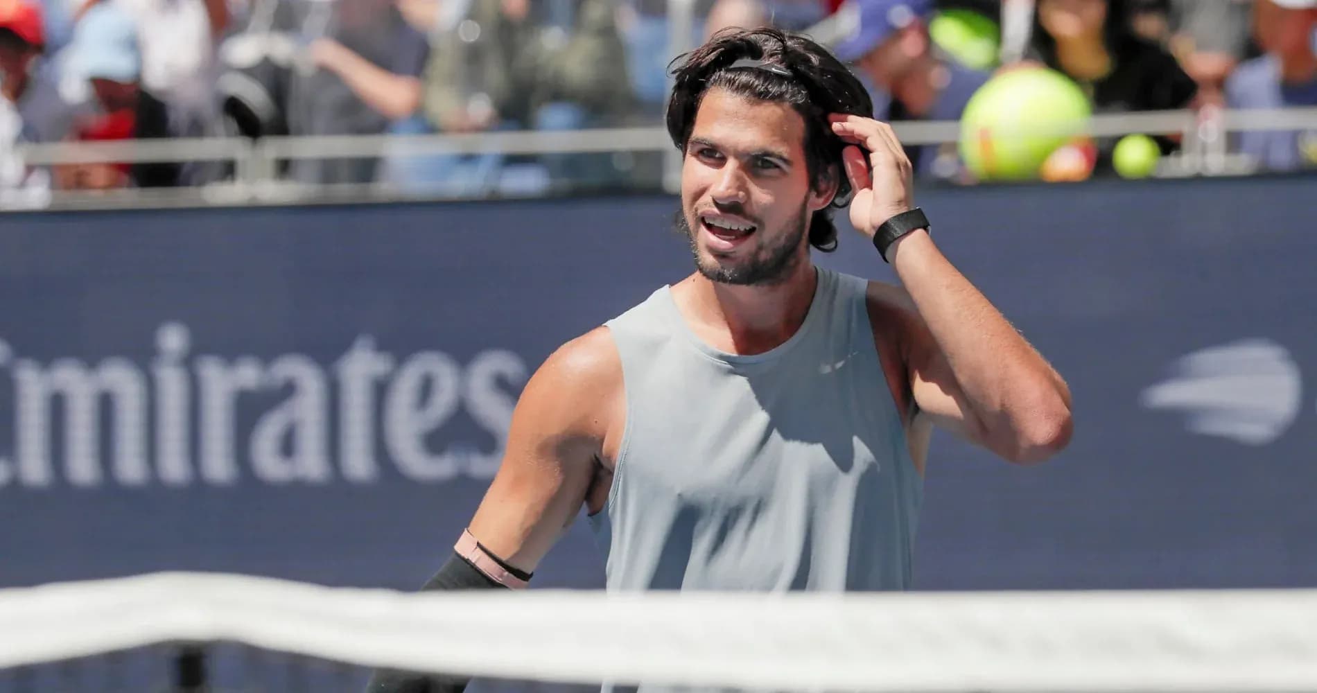 Joueur de tennis ajustant ses cheveux sur le court