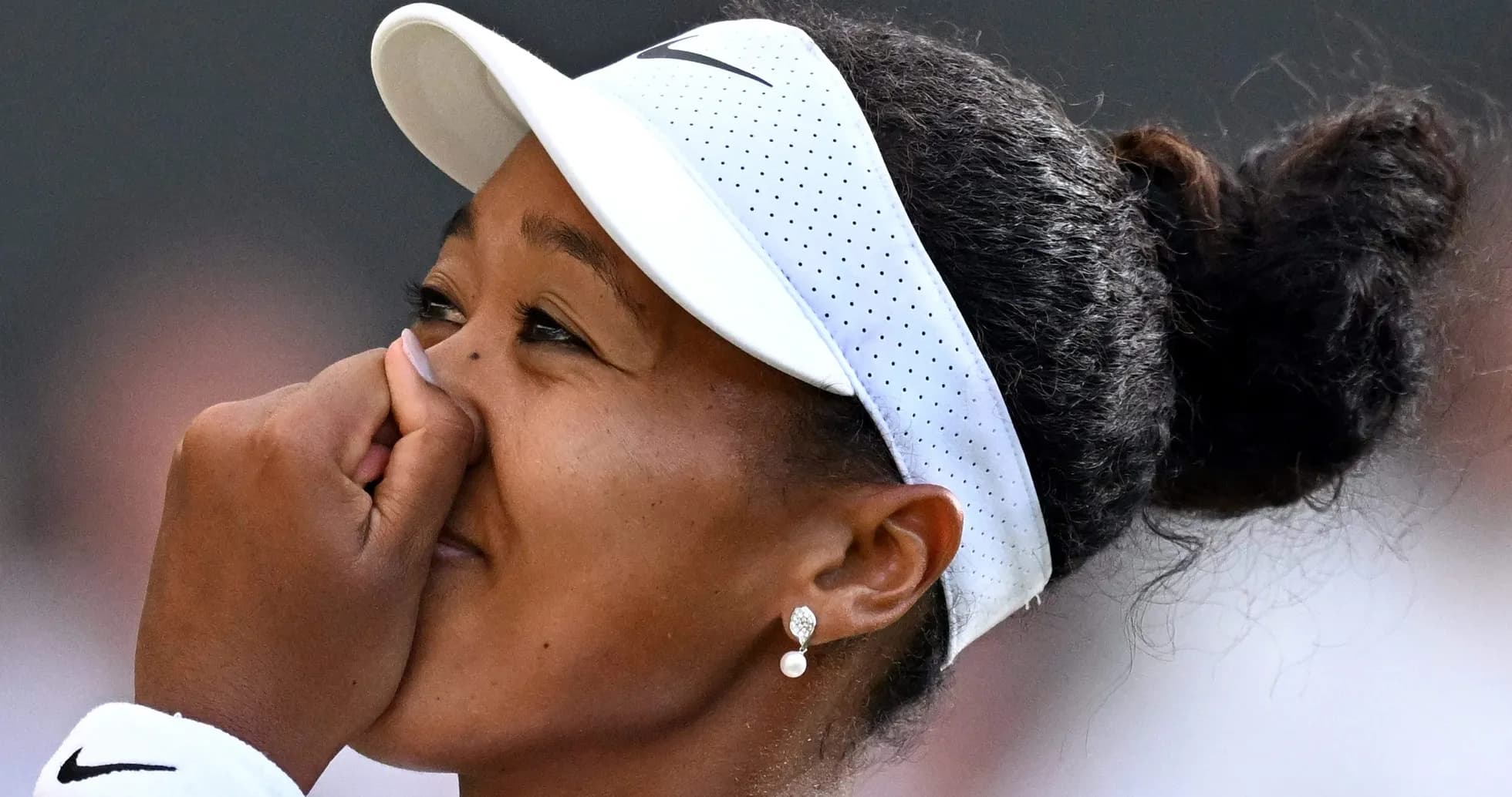 Joueuse de tennis touchant son visage pendant un match