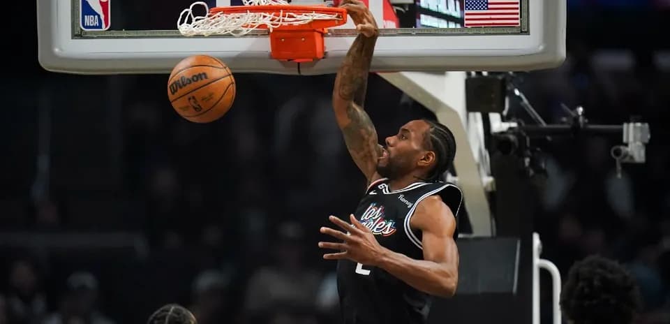 Joueur dunkant au panier lors d'un match NBA