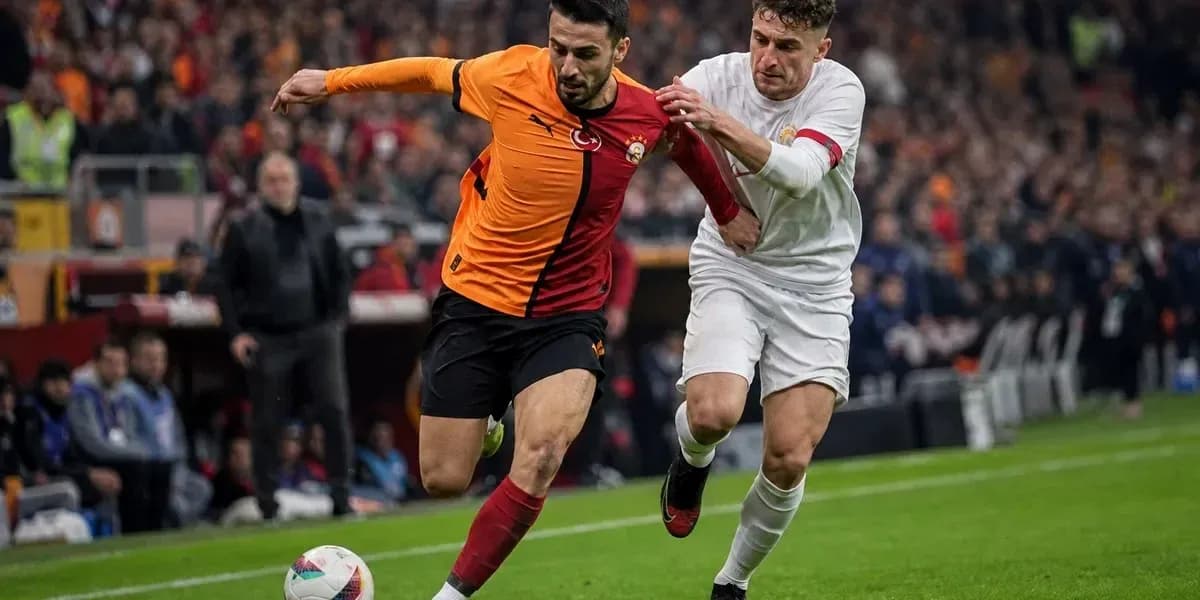 Joueur de Galatasaray dribblant sous pression d'un adversaire