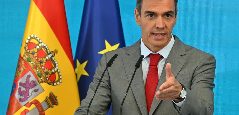 Homme parlant à un podium avec drapeaux espagnol et européen