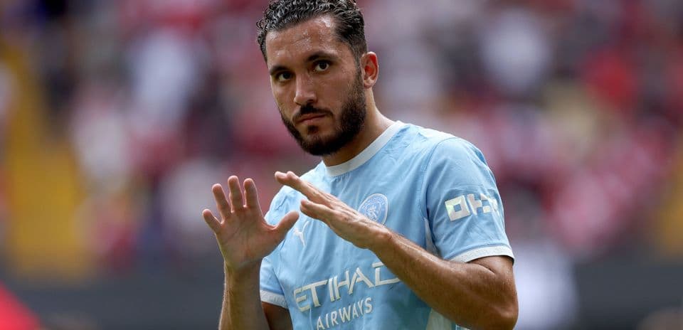 Joueur en maillot bleu saluant le public au stade