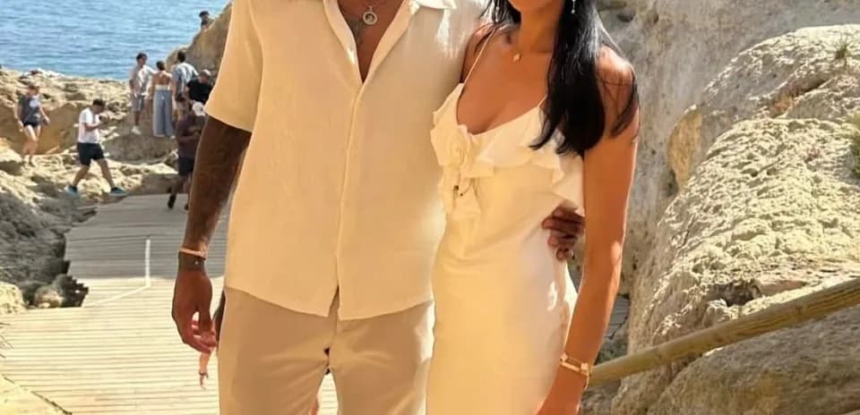 Couple posing together near rocky seaside