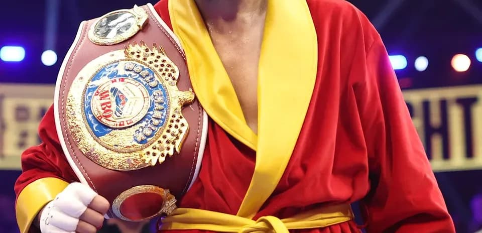 Boxeur en robe rouge tenant une ceinture de champion