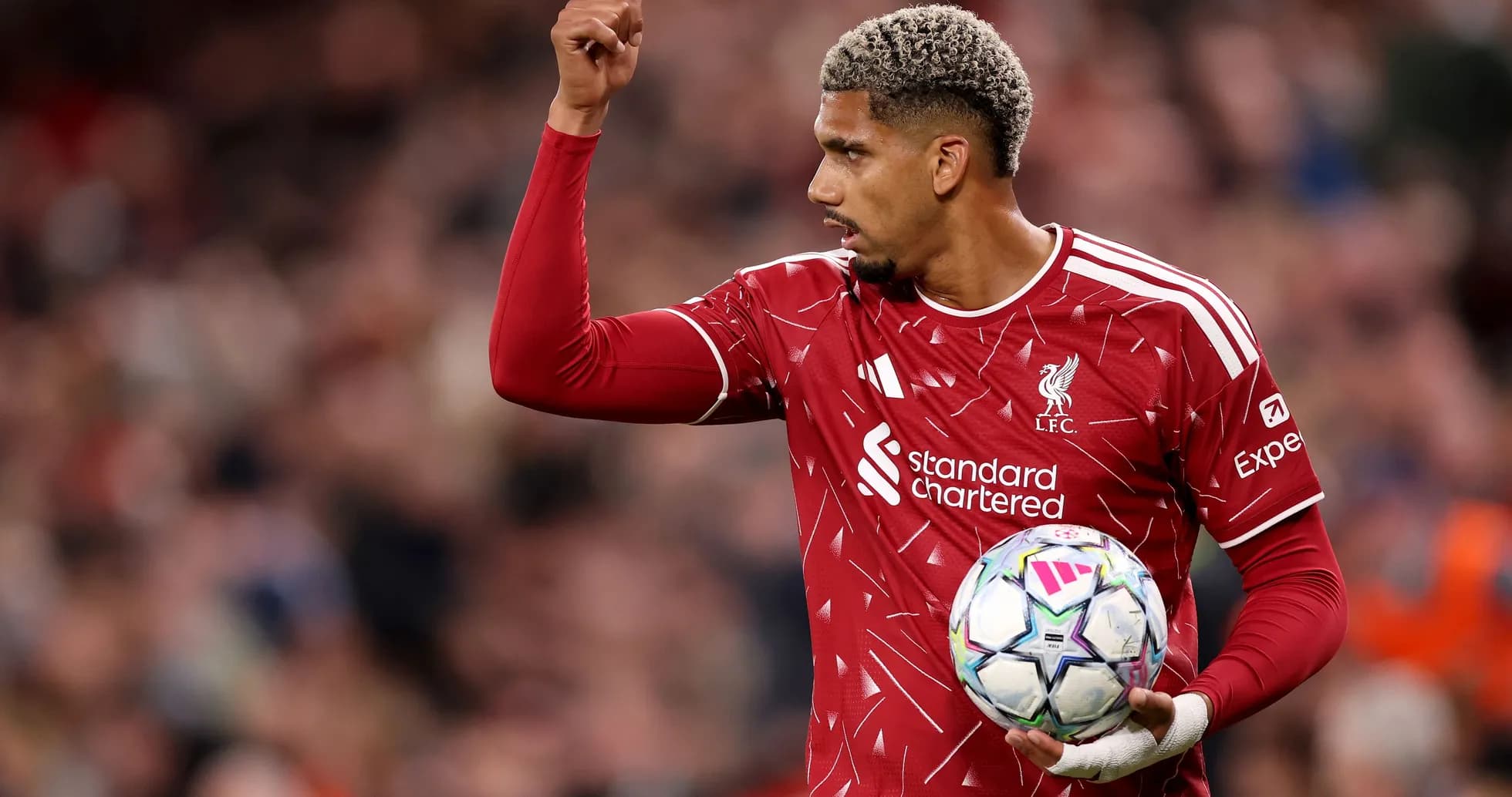 Joueur de Liverpool levant la main avec le ballon