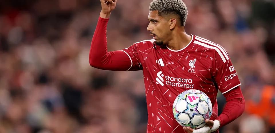 Joueur de Liverpool levant la main avec le ballon