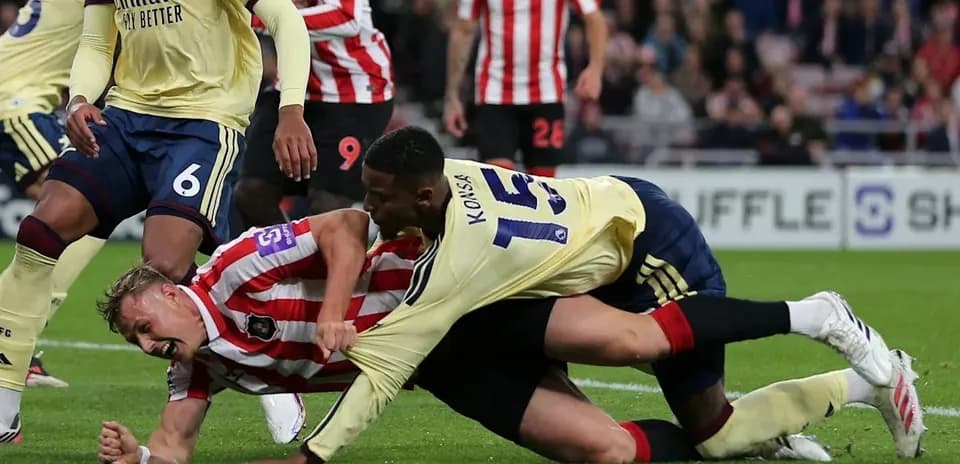 Joueurs au sol lors d'un affrontement sur le terrain
