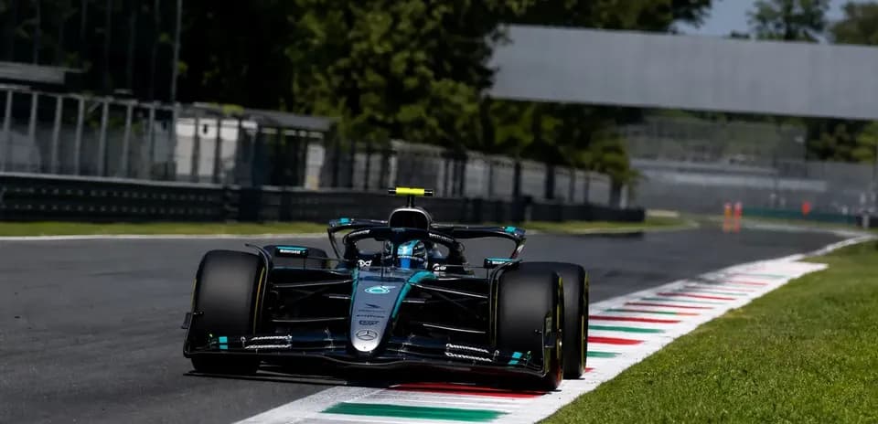 Voiture de Formule 1 sur circuit avec herbe