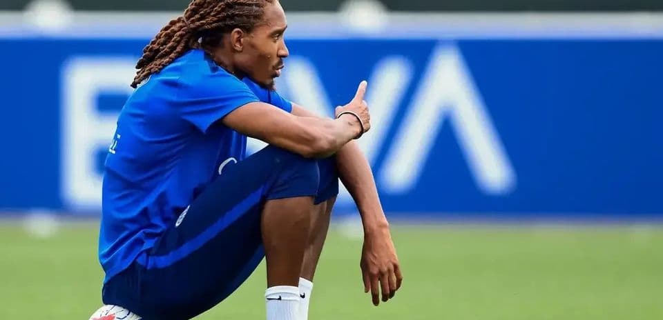 Joueur assis sur le terrain avec un ballon