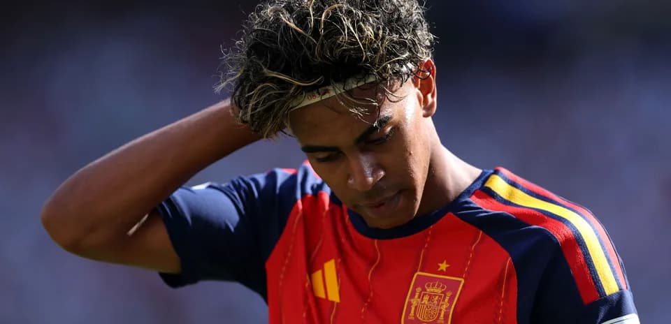 Joueur en maillot de l'Espagne touchant ses cheveux