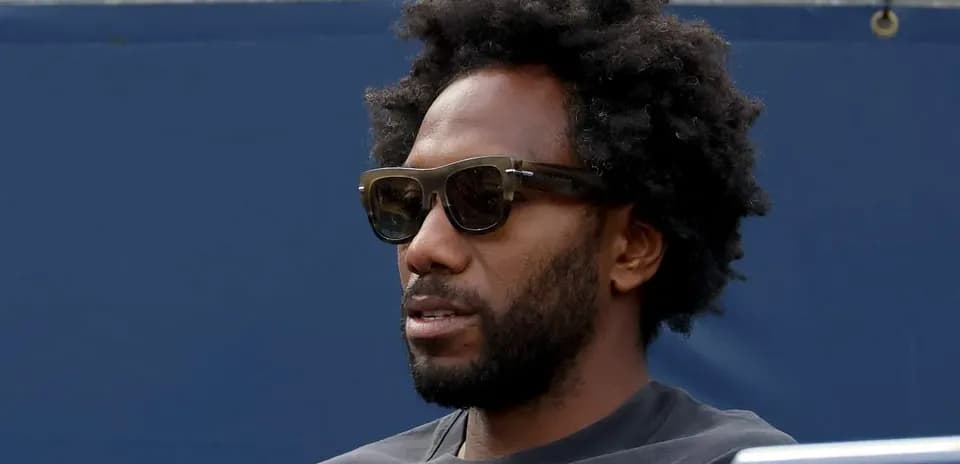 Homme avec lunettes de soleil assis sur les gradins