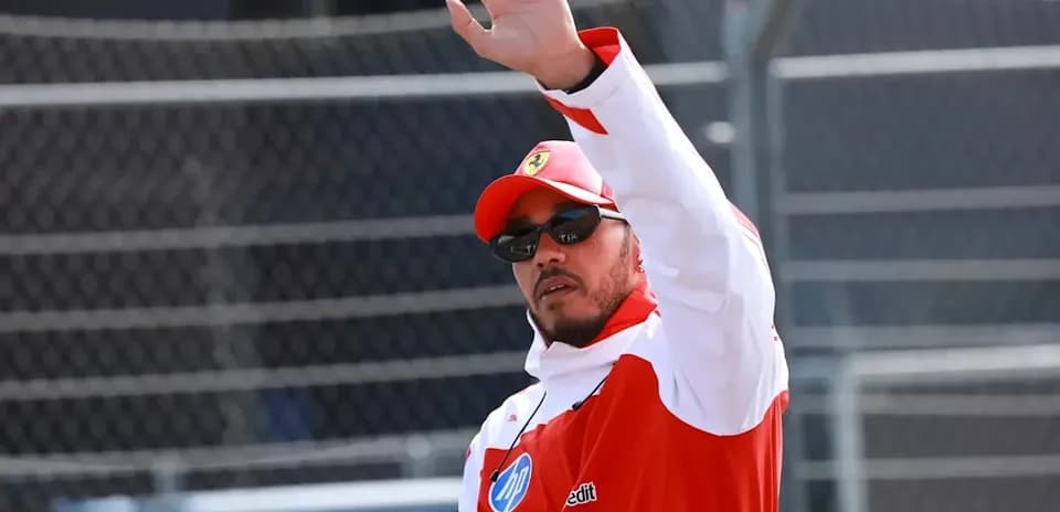 Pilote saluant avec la main sur le circuit