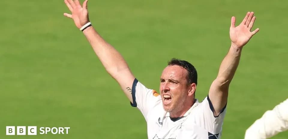 Joueur de cricket levant les bras en signe de victoire