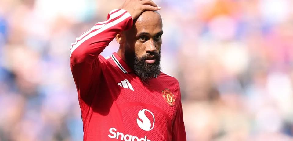 Joueur de Manchester United touchant son front sur le terrain