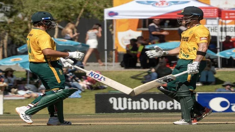 Deux joueurs de cricket se félicitent sur le terrain