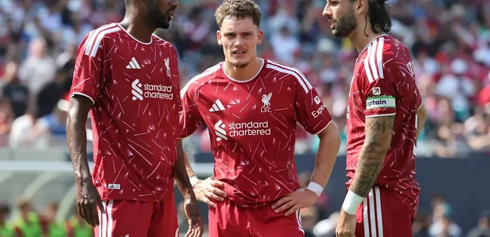 Trois joueurs de Liverpool discutant sur le terrain