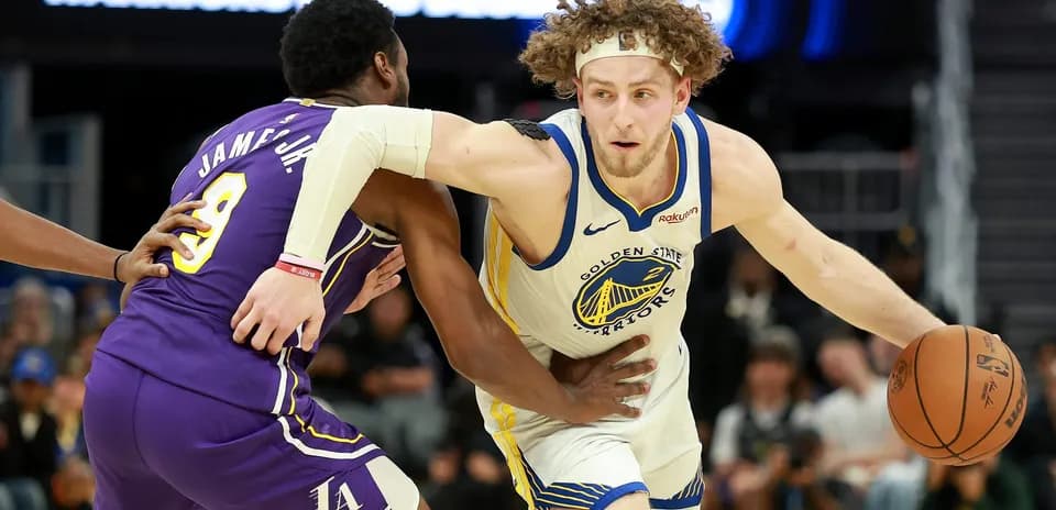 Joueur des Warriors dribblant sous la pression d'un adversaire