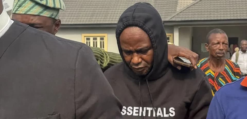 Homme en sweat à capuche entouré de personnes