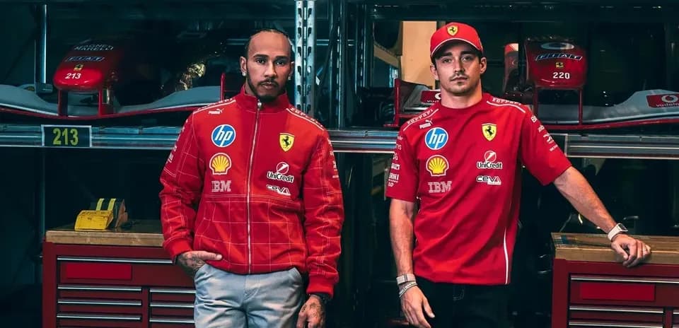Deux pilotes en tenue Ferrari dans un garage