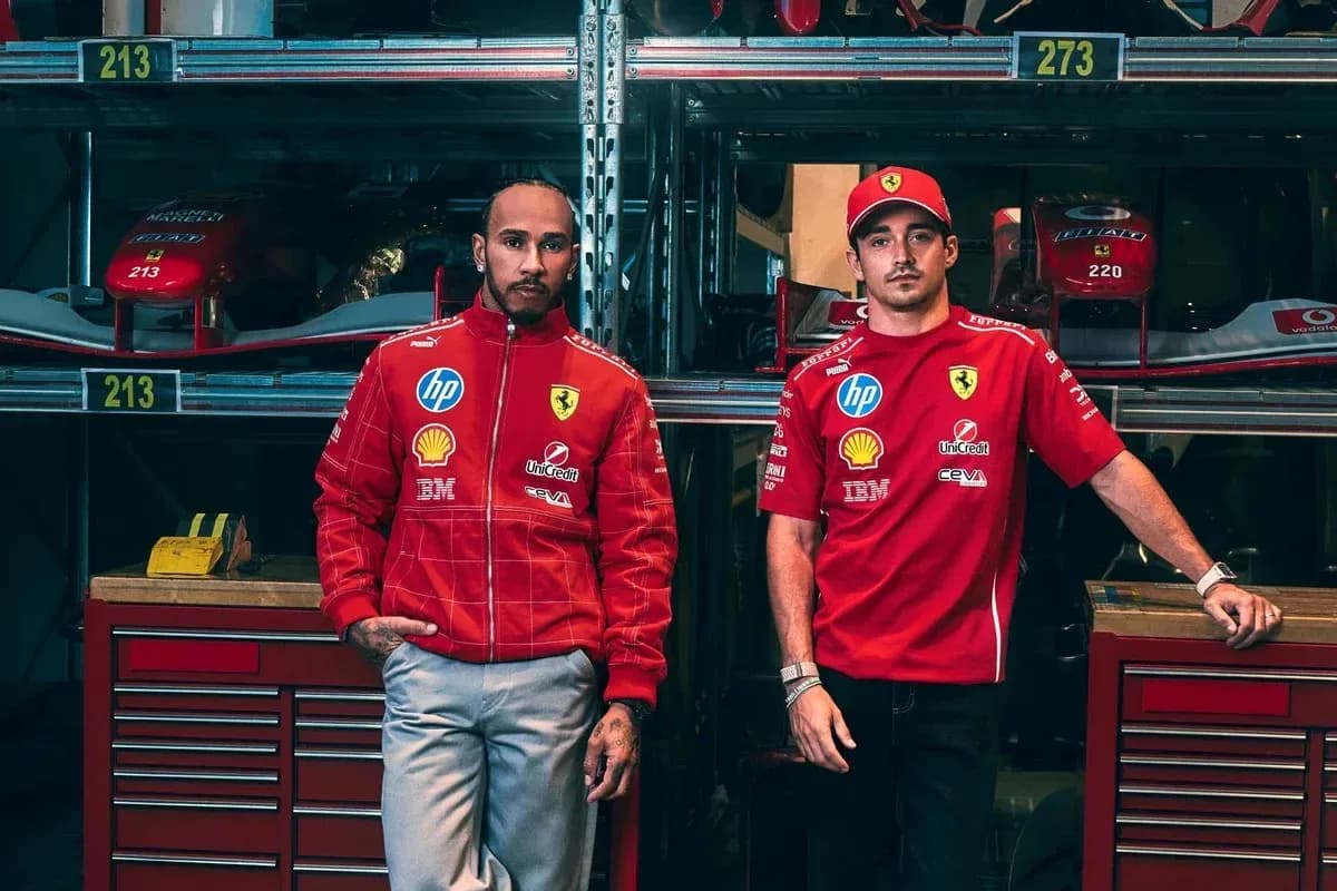 Deux pilotes en tenue Ferrari dans un garage