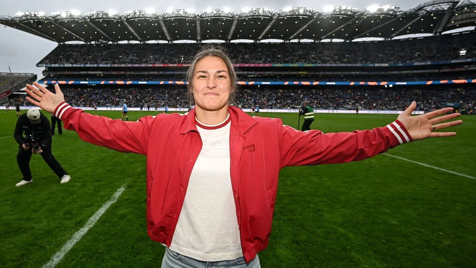 Femme souriante sur le terrain de rugby avec les bras ouverts