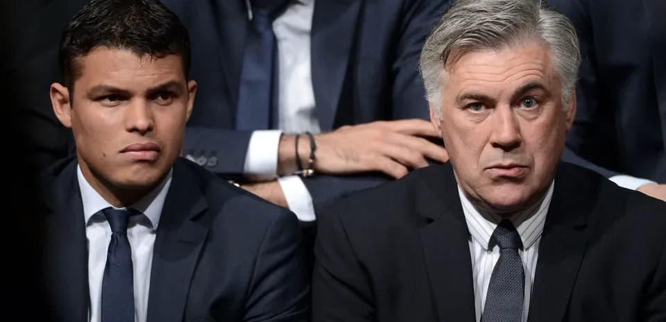 Deux hommes en costume assis, attentifs lors d'un événement