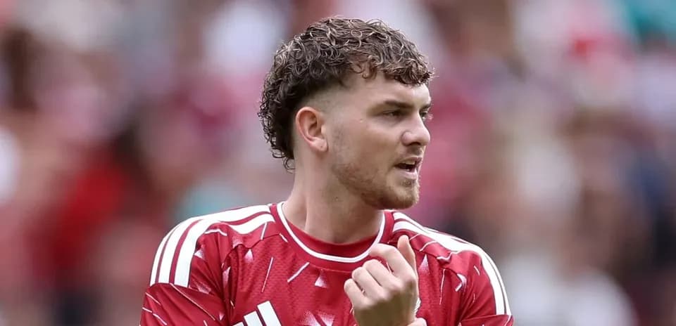 Joueur en maillot rouge se préparant sur le terrain